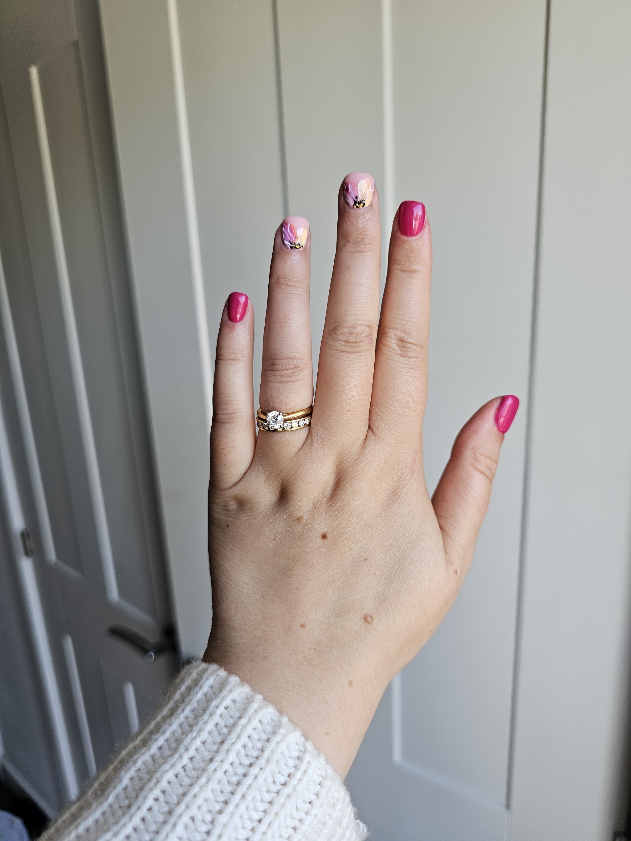 Full hand with pink nails and floral accents, photographed by Jemima Clark