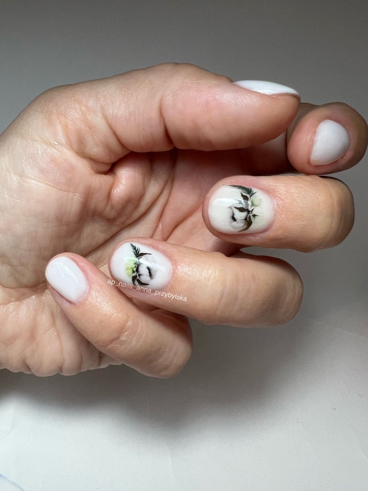 White manicure with delicate hand-painted floral nail art