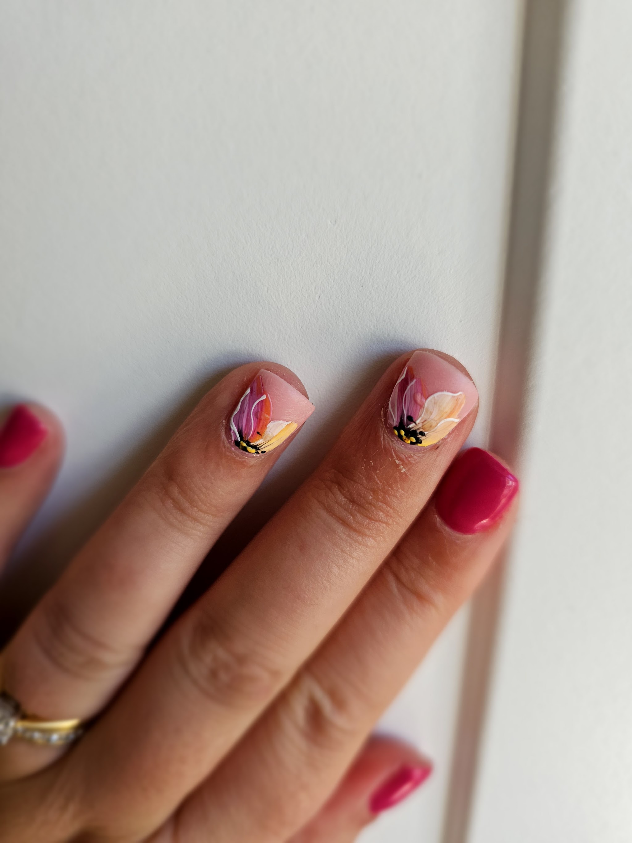 Close-up of pink and coral flowers on a customer's nails